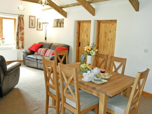 博德明斯戴普斯乡村别墅的客厅配有木桌和椅子