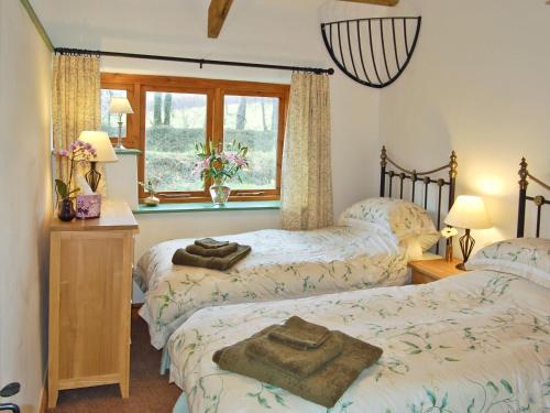 博德明斯戴普斯乡村别墅的一间卧室设有两张床和窗户。