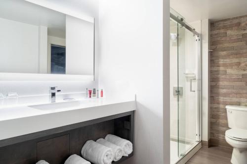 格罗顿万豪米斯提水疗酒店的一间带水槽和镜子的浴室以及一个壁炉
