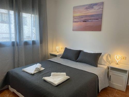巴达洛纳Beach Apartment Artigas的一间卧室配有一张床,上面有两条毛巾