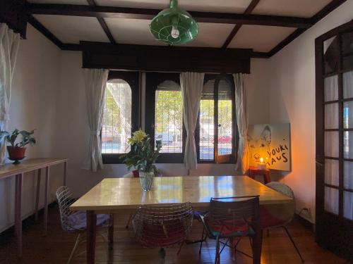蒙得维的亚Youki Haus Hostel的一间带桌椅和窗户的用餐室