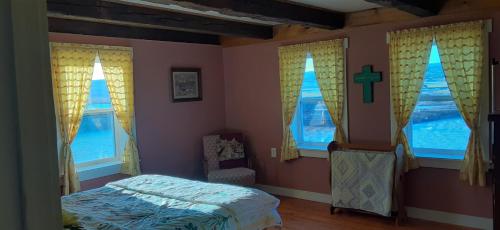 RiversideMountainview Solitude Inn的卧室设有窗户,墙上有十字架