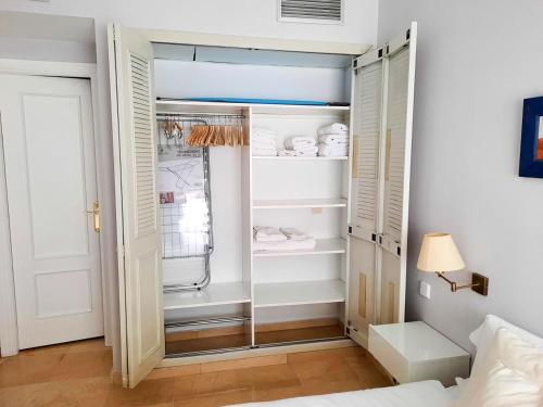 塞维利亚Triana Suite Torre Sevilla, parking free gratis!的一间卧室设有步入式衣柜和淋浴