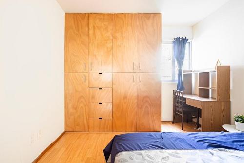 墨西哥城Habitación en Napoles cerca de WTC的一间卧室配有大型木制橱柜和一张书桌