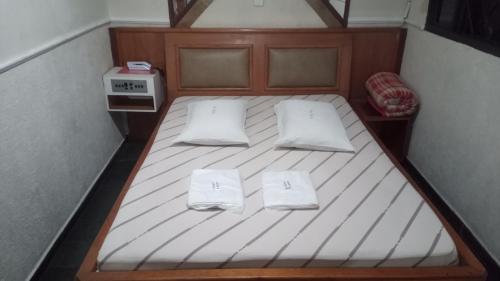 圣保罗Hotel Malibu (ADULT ONLY)的一张小床,上面有两个白色枕头