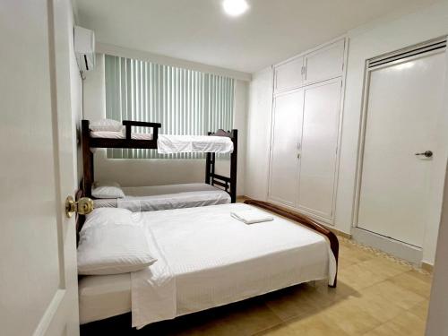 卡塔赫纳APARTAMENTO AMOBLADO BOCAGRANDE Cartagena的一间卧室配有两张双层床和一个衣柜