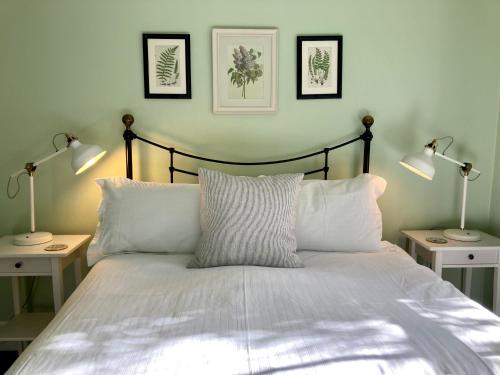 格雷敦Country Bliss Cottage的一间卧室配有一张带两盏灯的床。