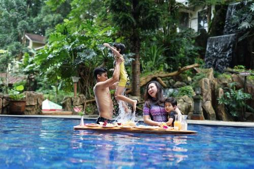 普卡Safari Resort的游泳池里木筏上的女人和两个孩子