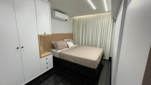戈亚尼亚Condomínio encantador de luxo的一间小卧室,配有一张床和镜子