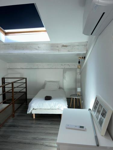 BramMaison climatisée avec stationnement et wifi的一间小卧室,配有一张床和一张桌子
