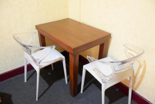 库鲁内格勒Janara Two的一张木桌和两张椅子,旁边是一张桌子