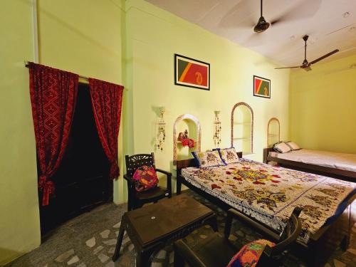 本迪Haveli Gulabram Ji, Bundi的卧室配有一张床和一张桌子及椅子