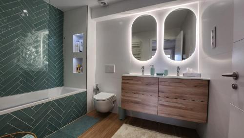 罗萨斯Mediterranean apartment Rosas的一间带水槽、卫生间和镜子的浴室