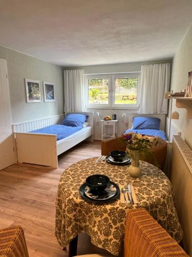 萨斯尼茨Sonnige Souterrain-Ferienwohnung的一间卧室配有两张床和一张桌子及椅子