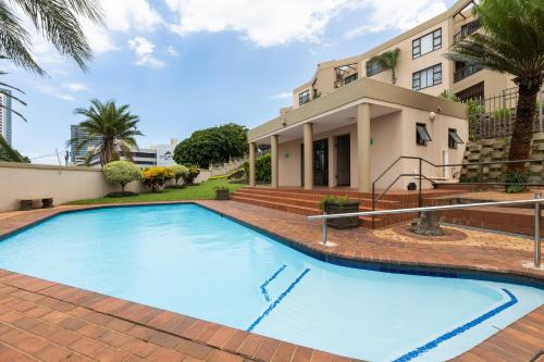 德班67 The Shades - Luxury Apartment in Umhlanga - Airconditioning throughout and Inverter的房屋前的大型游泳池