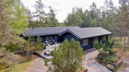 埃克奈斯Villa Mustikka的森林中间的蓝色房子