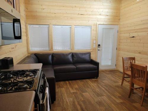 瓦莱036 Tiny Home nr Grand Canyon South Rim Sleeps 8的客厅配有黑色沙发和炉灶。