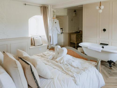 PentneyFarmhouse - Ukc6630的一间白色卧室,配有浴缸和一张床
