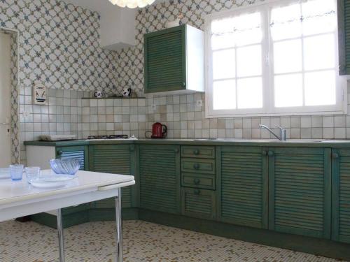 拉康提内勒Maison Saint-Pierre-d'Oléron-La Cotinière, 4 pièces, 8 personnes - FR-1-246A-34的厨房配有绿色橱柜和白色桌子