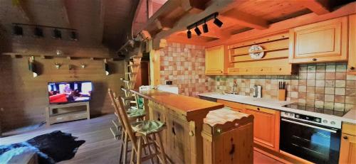 尼德恩西尔AlpinResort DerBacherhof的一个带柜台的厨房和一台背景电视