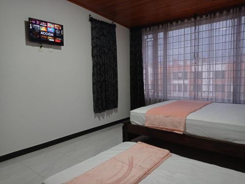 派帕Comoda casa para descansar en Paipa & excelente ubicacion的一间卧室设有两张床和窗户。