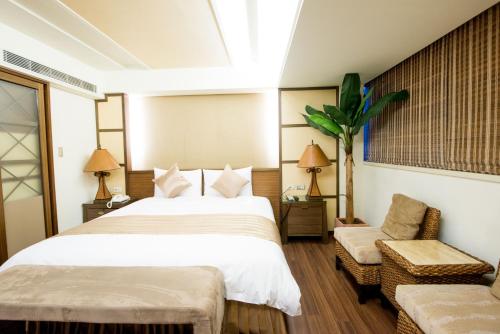 新竹新苑名流都會館 的一间卧室配有一张大床和一把椅子