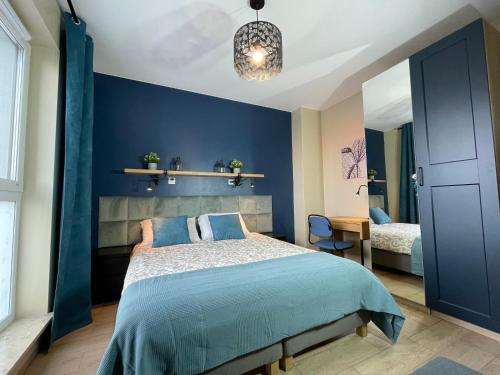 格但斯克Superior Baltea 3 rooms, Beach 800m, AirCondition的一间卧室设有蓝色的墙壁、一张床和一张书桌