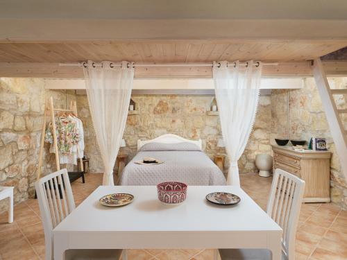 阿卡尼斯The Olive Grove Cottage with private swimming pool的卧室配有一张床和一张桌子及椅子
