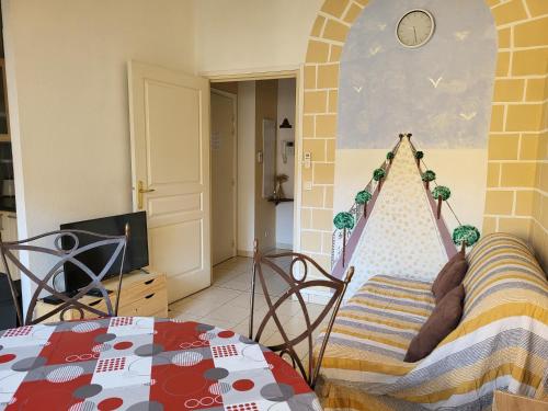 圣罗兰度瓦Appartement traversant et lumineux avec terrasse的一间客房内配有桌子和吊床的房间