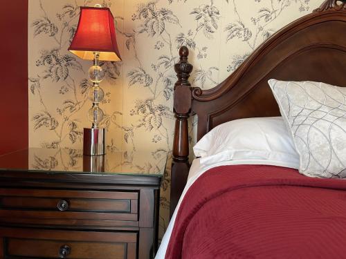 滨湖尼亚加拉Darlington House Bed and Breakfast的一间卧室配有一张床,梳妆台上配有一盏灯