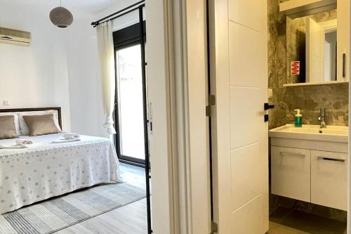 卡斯Ozy Apart Garden / Kaş-Çerçiler的一间卧室配有一张床,浴室设有水槽