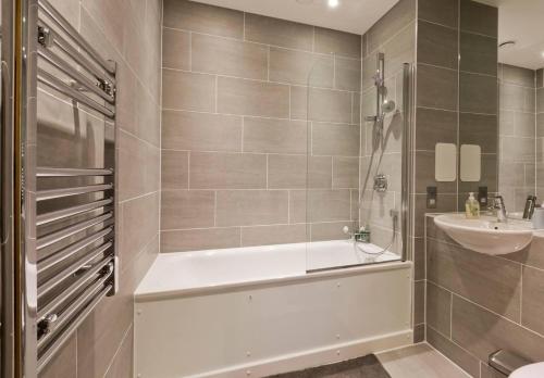 伦敦2-Bed Apartment only 15 mins from Central London的带浴缸和盥洗盆的浴室