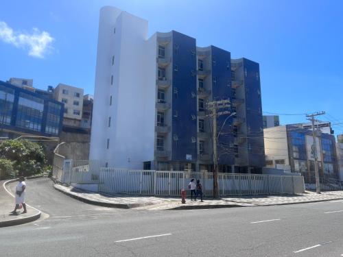 萨尔瓦多Apartamento em Amaralina的街道旁高大的建筑,有栅栏