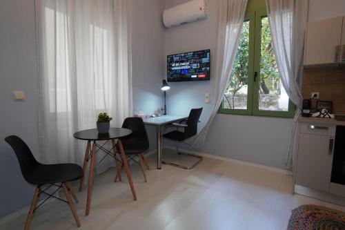 雅典City Break Metro Ambelokipi的客厅配有桌椅和窗户。