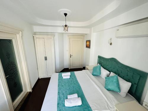 伊斯坦布尔La Petite Maison Hotel的一间卧室配有绿色和白色的床以及蓝色枕头