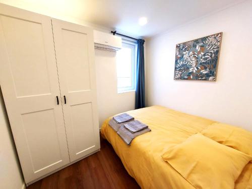 科维良Ritta´s House - Covilhã的一间设有黄色床和窗户的小卧室
