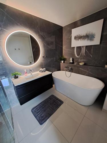 卑尔根Bergen sunrise Apartment - self check in - Free Parking的带浴缸、水槽和镜子的浴室