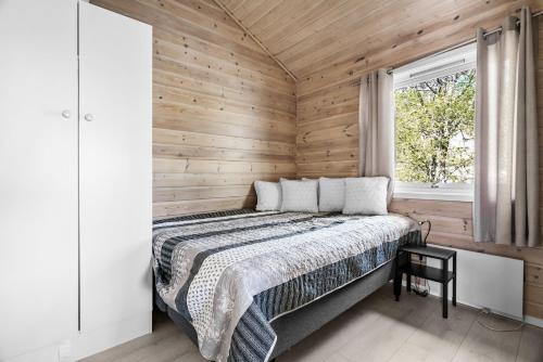 弗洛罗Krokane Camping Florø的卧室配有木墙内的一张床