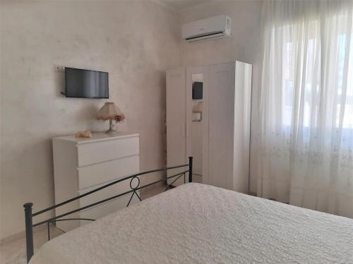 加利波利Gallipoli - Lido S. Giovanni - 200 meters from the sea的卧室配有一张床,墙上配有电视。