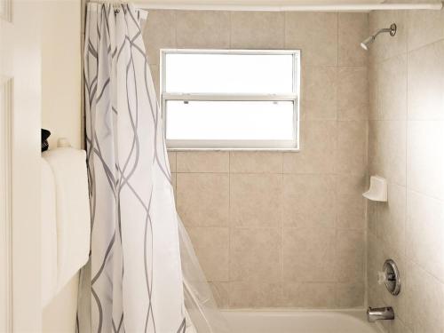 达文波特4 Bed 428的带淋浴帘和窗户的浴室