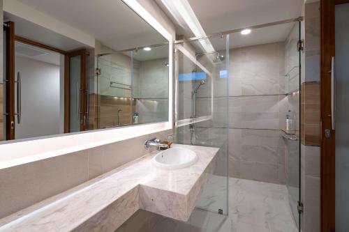 苏梅岛Samui Privacy Modern Luxury Seaview Natural Rainforest Infinity Pool Villa的一间带水槽和玻璃淋浴的浴室