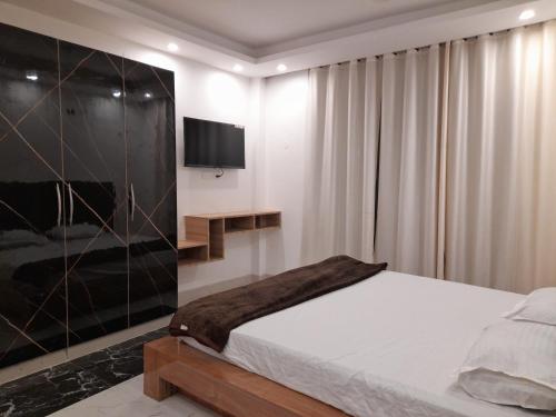 BegusaraiAshoka Resort & Banquets的一间卧室配有一张床,墙上配有电视