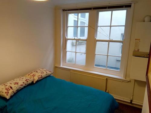 贝克斯希尔Lovely 1-bedroom flat within minutes from the beach!的一间卧室设有蓝色的床和窗户。