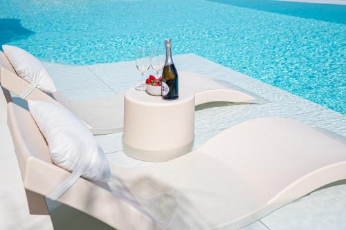 阿斯格罗Gatsby Rhodes-Brand New Seaview Villa的一张桌子,旁边是一瓶葡萄酒和椅子