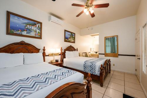 阿瓦隆Casa Mariquita Hotel by Omeo的一间卧室配有两张床和吊扇