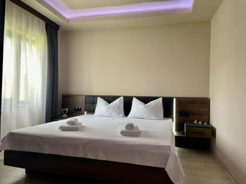 Tserova KoriyaКъща за гости ЕМ Парадайс的卧室配有一张带白色床单和枕头的大床。