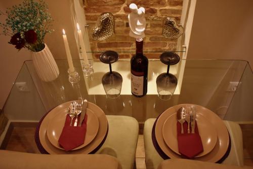 拉夫里翁Harmony 2 in Gold的一张桌子,上面放两个盘子和一瓶葡萄酒