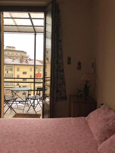 库尼奥casa silvio pellico的一间卧室配有一张床,阳台配有桌子