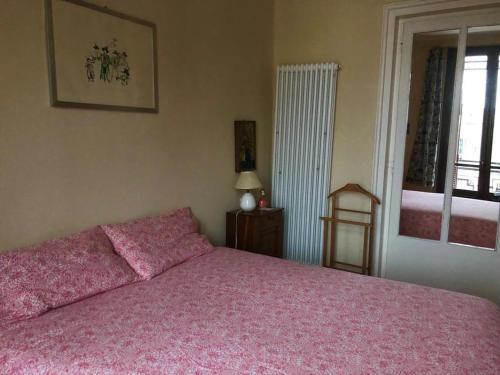 库尼奥casa silvio pellico的卧室配有粉红色的床和窗户。