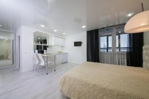 克拉斯诺亚尔斯克Apartment Aviator 38的一间白色卧室,配有一张大床和一个厨房